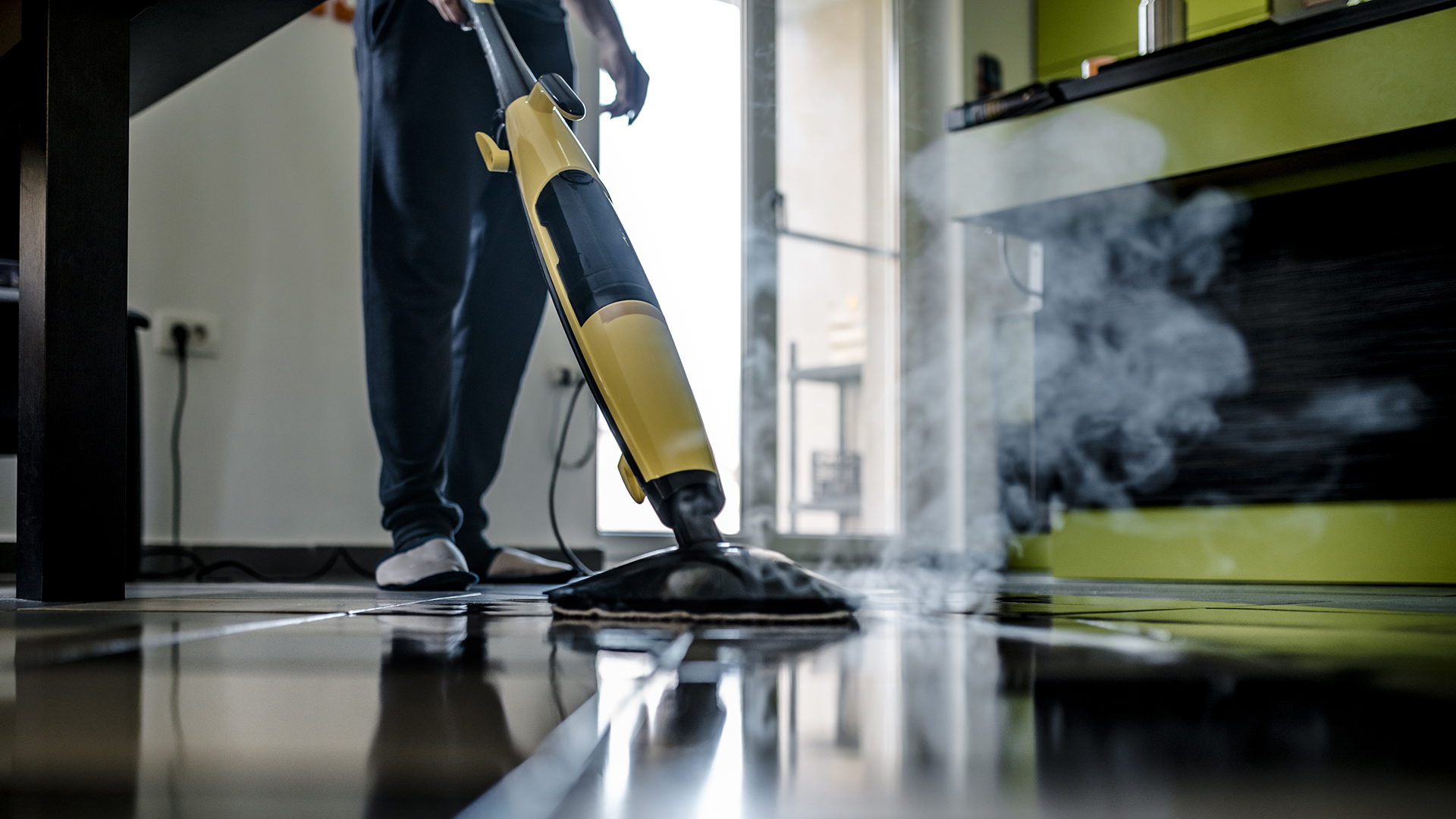 Man cleaning the floor with a dry steam cleaner